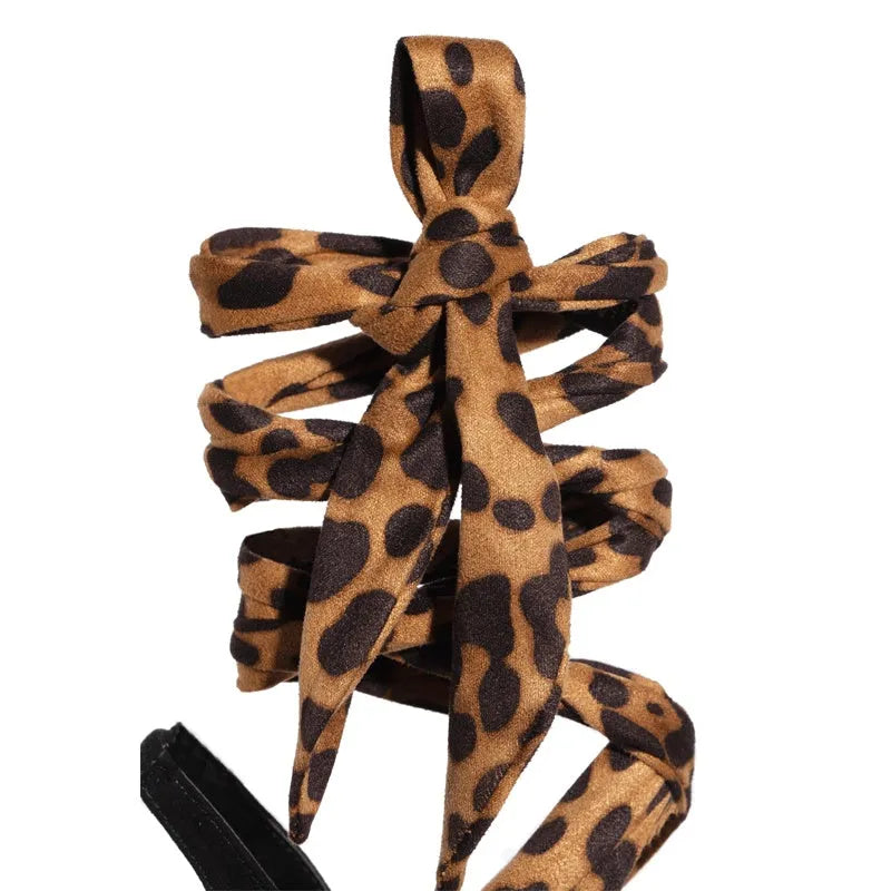Light brown leopard print women's high-heeled sandals with Roman cross straps and a thin high heel.