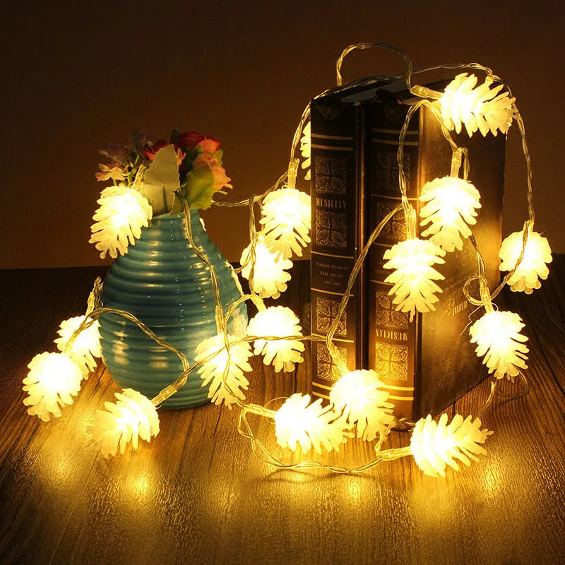 Warm white LED pine cone light string hanging decoratively, showing plastic shell details.