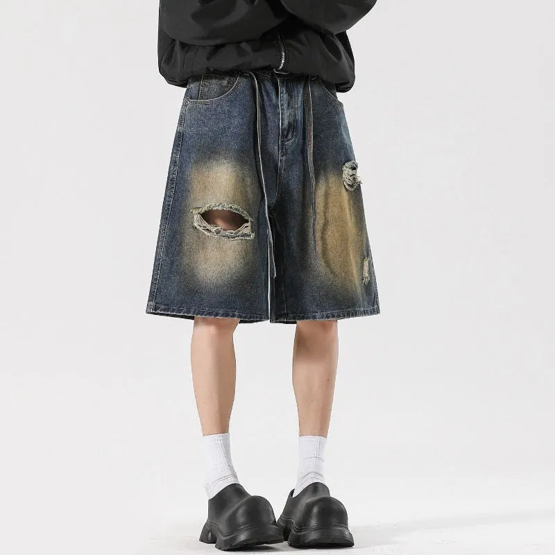 Man's retro blue loose fit jeans with ripped detailing on knees and thighs.