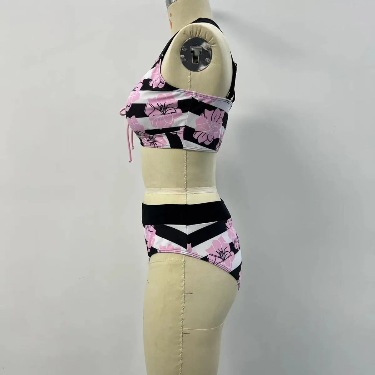 Black women's printed bikini with belly cover and split-leg design for swimming.