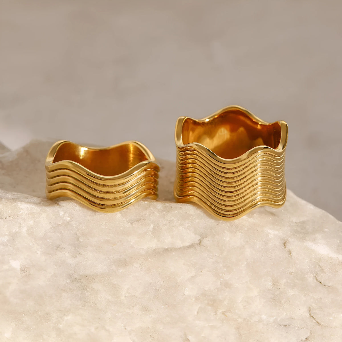 Close-up of a stainless steel geometric wave ring with a wide, sculpted surface.