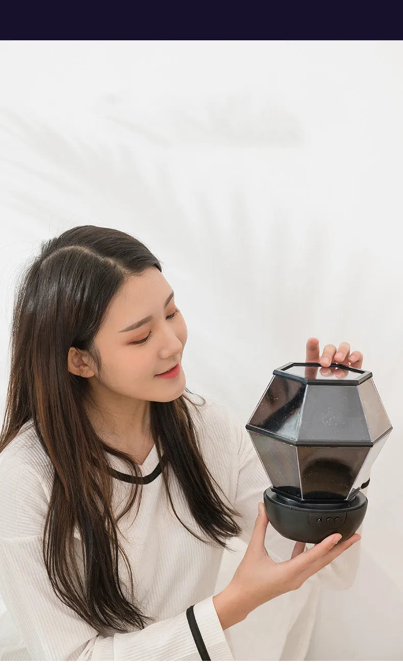 Children's rotating star night light showing three colour LED illumination in bedroom setting