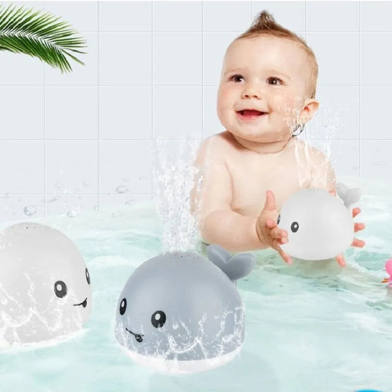 Automatic spray whale baby bath toy with LED lights on a blue base