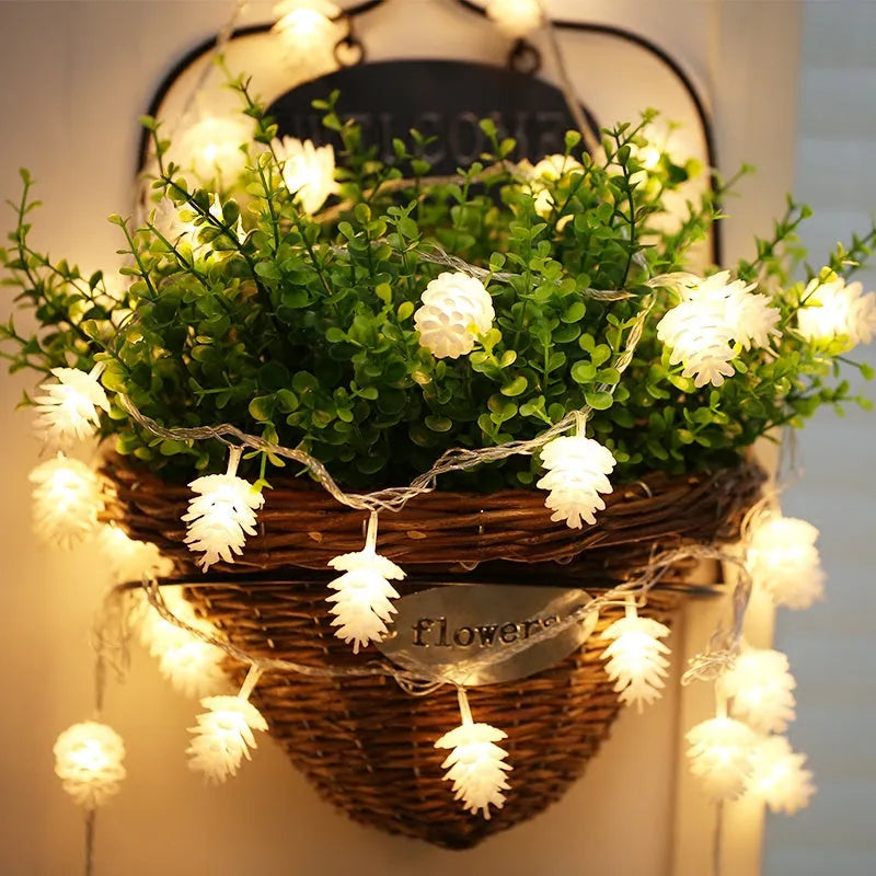 Warm white LED pine cone light string hanging decoratively, showing plastic shell details.