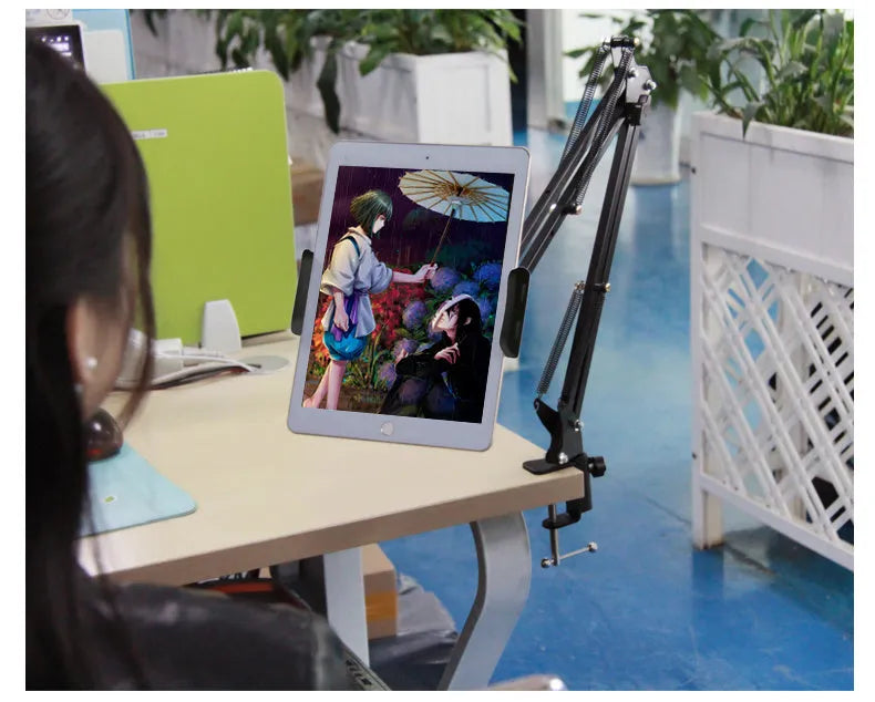 Adjustable black and white phone tablet stand on flat surface with mobile device
