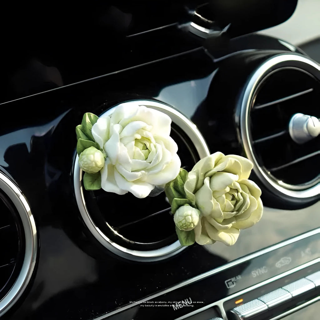 Jasmine car perfume solid air freshener in vent with gypsum base and essential oil bottle.