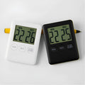 Black and white digital kitchen timer with magnetic back and display showing time