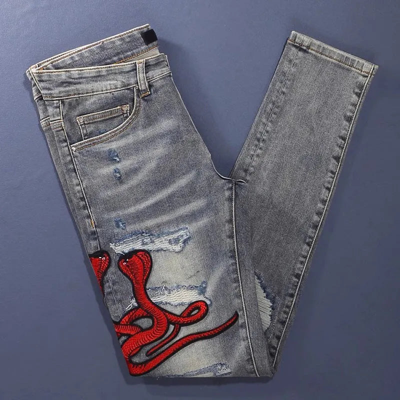 Old colour slim fit jeans with hole patches and embroidered detailing on worn cotton fabric