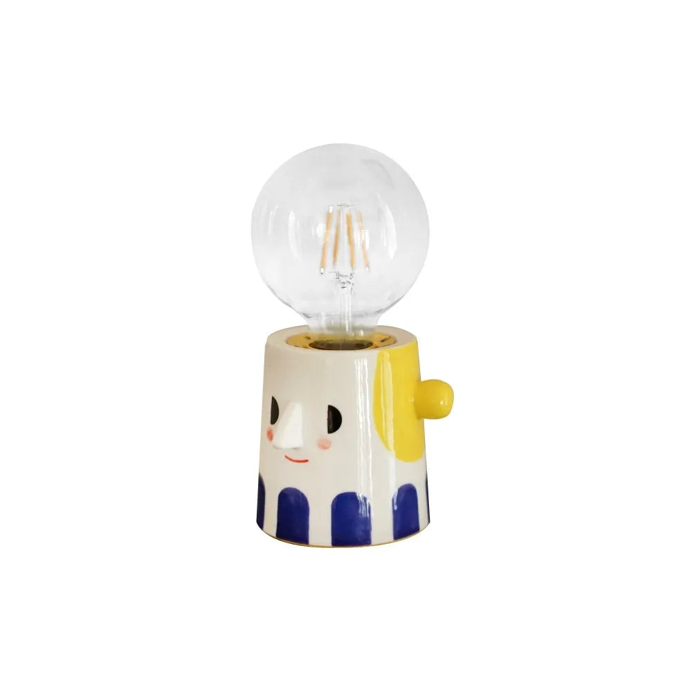 Handmade ceramic table lamp with white ball headlight design on wooden surface