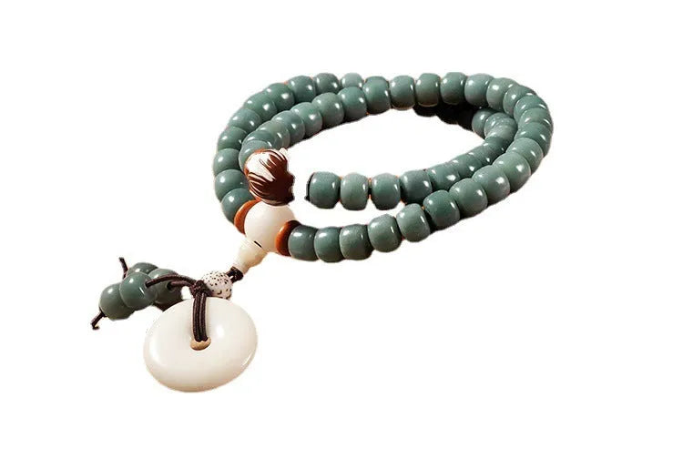 White jade and green sandalwood beaded bracelet with a double ring lotus safety buckle clasp.