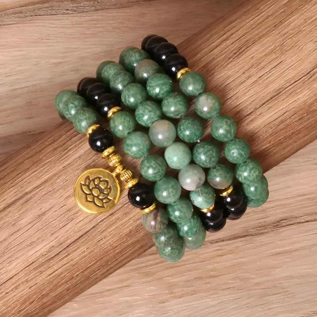 Green and black alloy bead elastic bracelet on wrist showing adjustable stretch design
