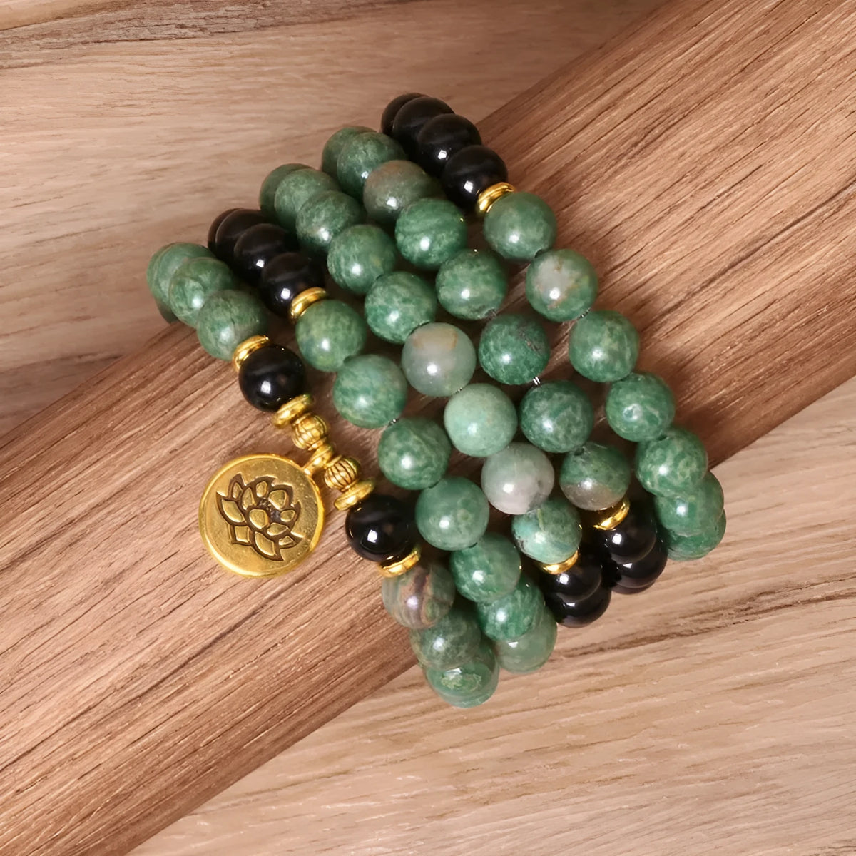 Green and black alloy bead elastic bracelet on wrist showing adjustable stretch design