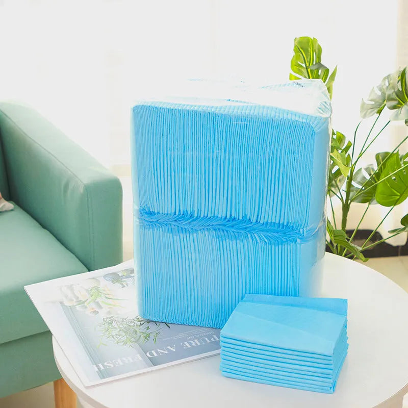 Pack of disposable absorbent pet urinal pads or diapers for dogs and cats on a floor.