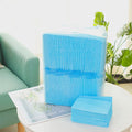 Pack of disposable absorbent pet urinal pads or diapers for dogs and cats on a floor.