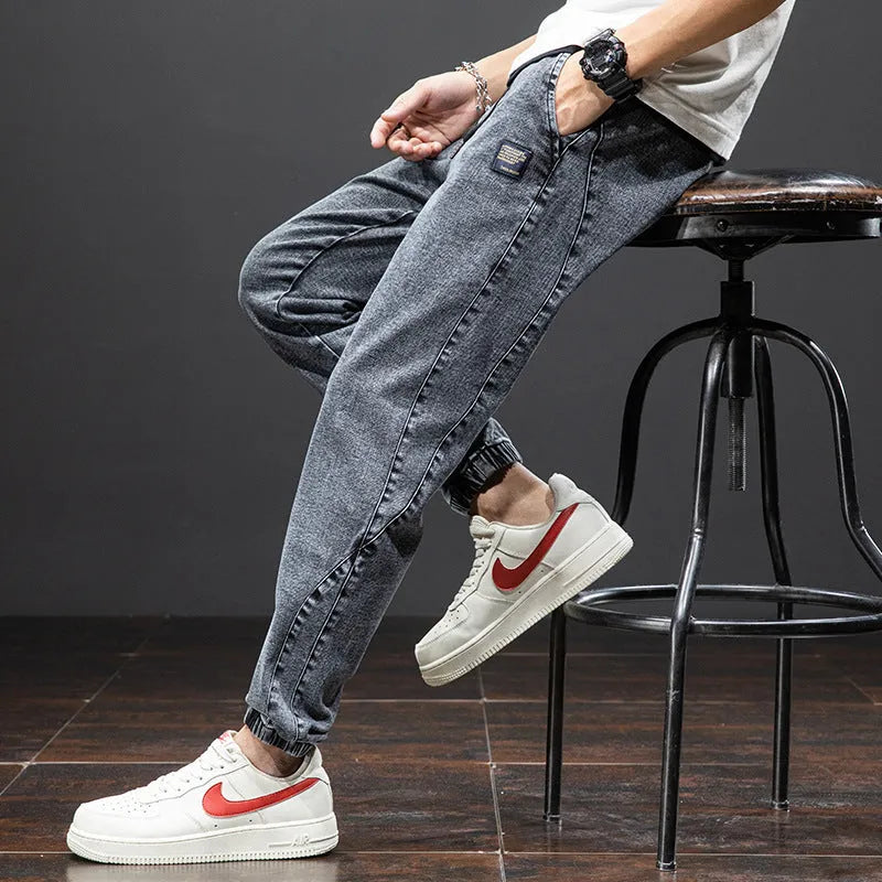 Man wearing straight leg cotton cargo jeans in blue, showing mid waist and skinny open leg style.