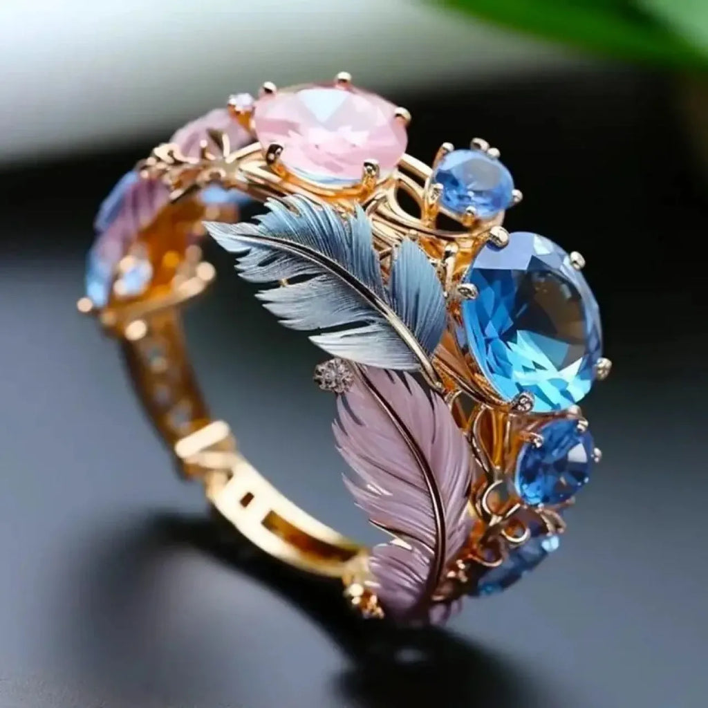 Gold tone brass feather ring with embossed design and zircon stones.