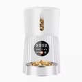 Black automatic pet feeder with digital display and food container showing portion control mechanism