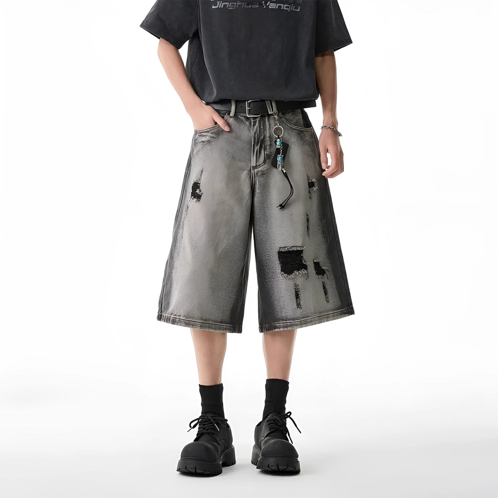 Women's loose-fit washed grey denim shorts with distressed hole details, cropped length.