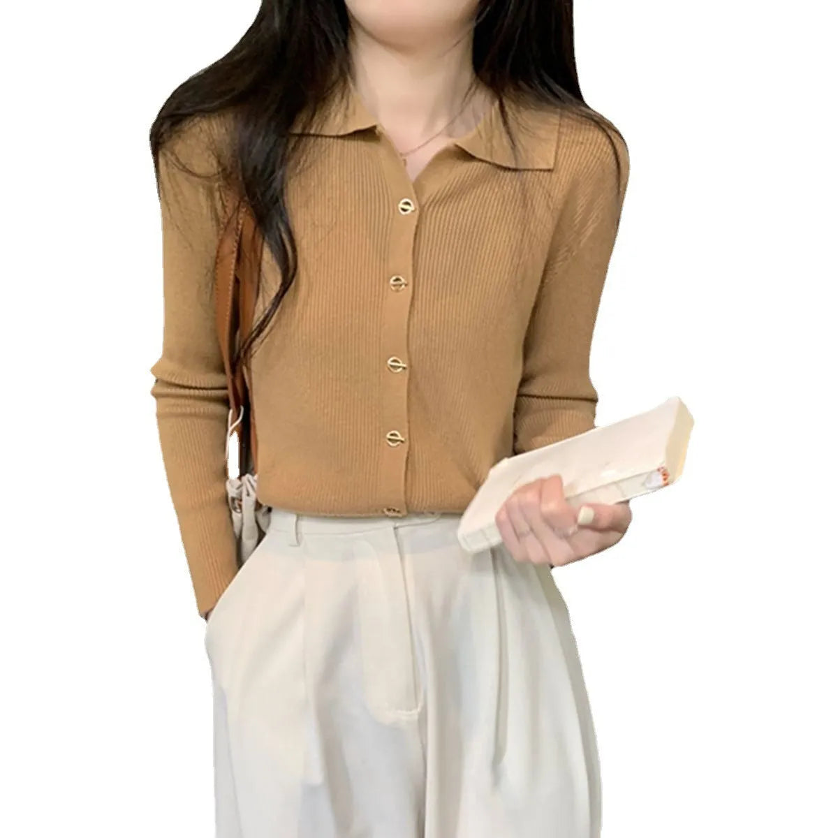 Beige long-sleeved viscose knitted cardigan hanging on a hanger, loose fit