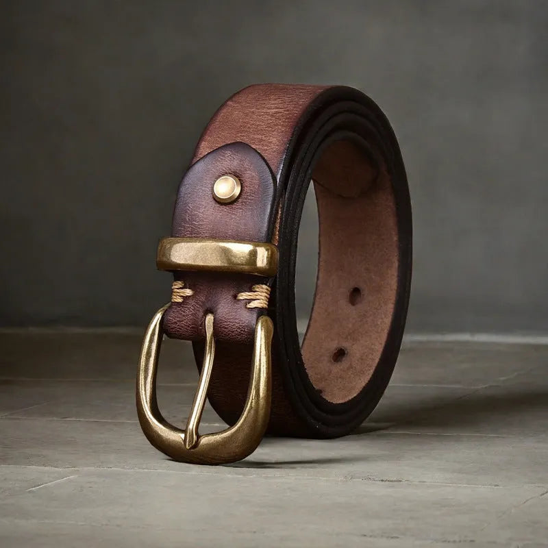 Men's black cattlehide leather belt with a copper pin buckle shown on a flat surface.