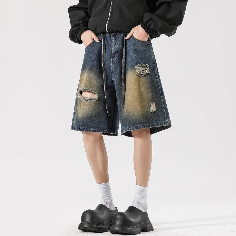Man's retro blue loose fit jeans with ripped detailing on knees and thighs.