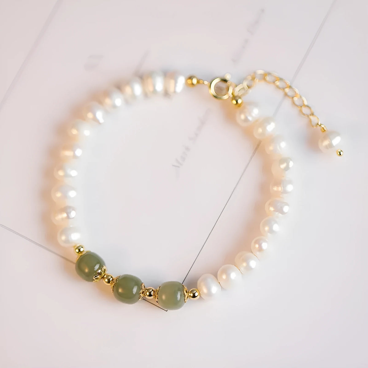 Diamond-shaped freshwater pearl bracelet in electroplated Hetian jade colour on a wrist.