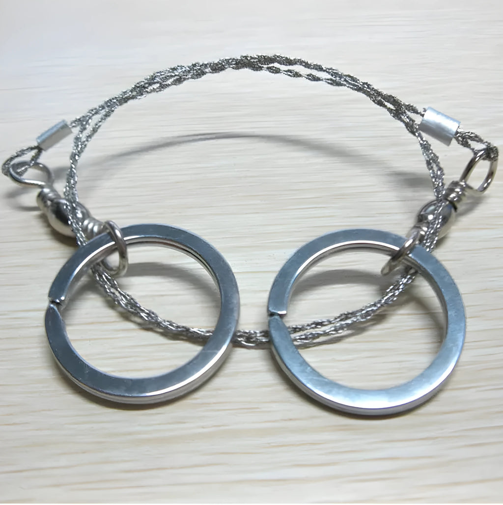 Survival wire saw with thumb rings extended to 70cm total length on a background.