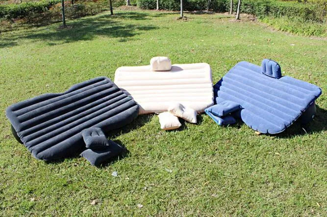 Universal inflatable car bed with flocked surface and pillows laid out in a car boot.