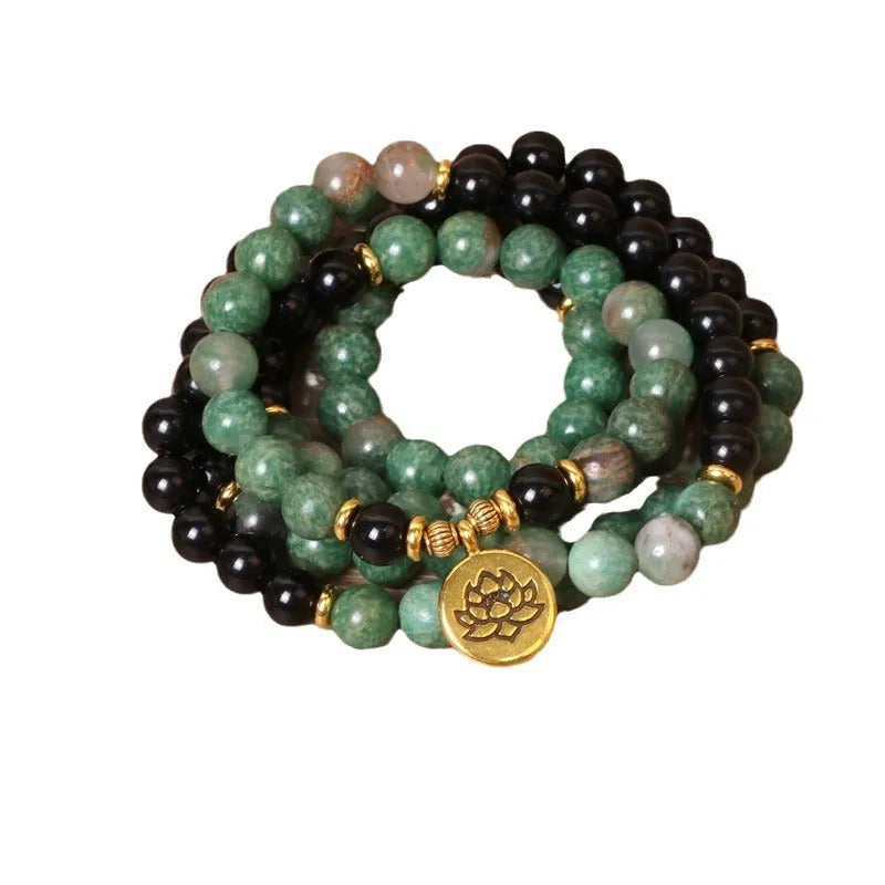 Green and black alloy bead elastic bracelet on wrist showing adjustable stretch design