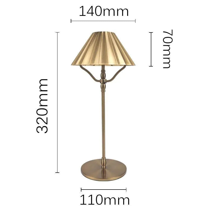 Gold alloy desk lamp with LED light source and interchangeable shade on wooden desk surface