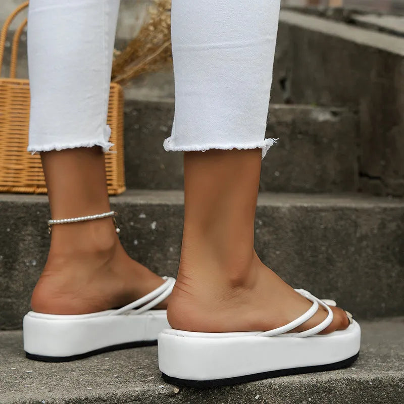 White thick-soled flip-flops with herringbone pattern PU upper and rubber sole.