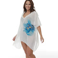 White plus size loose beach cover-up blouse for women on a beach.