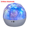 Compact white starry sky projector displaying blue constellation patterns on a dark wall.