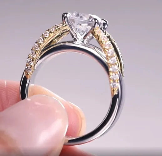 Geometric two-tone ring for women in brass and white steel, shown on a hand.