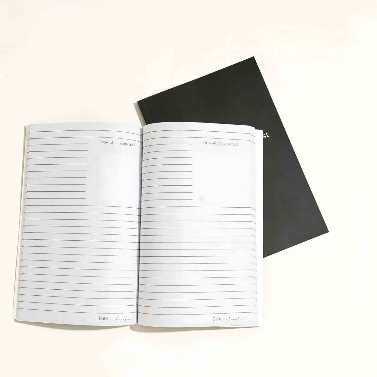 Black hardcover dream journal notebook with blank interior pages.