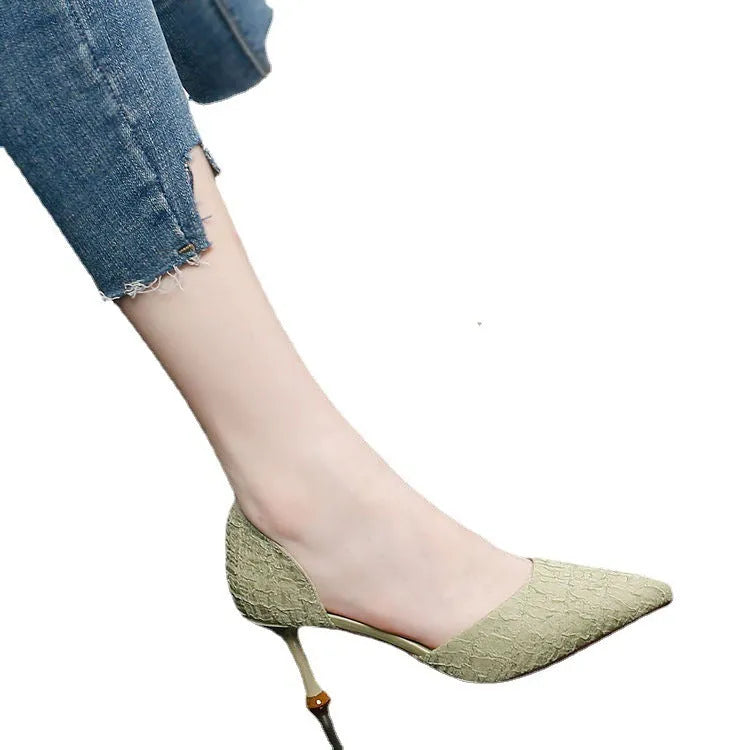 Women's black pointed toe stiletto high heel shoes on a plain background.