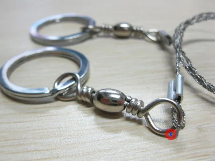 Survival wire saw with thumb rings extended to 70cm total length on a background.