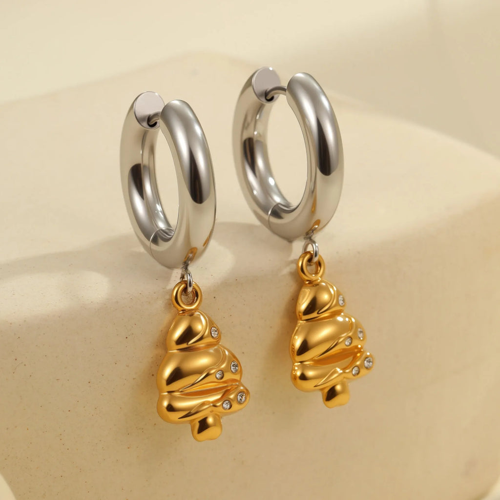 A pair of gold-coloured stainless steel earrings featuring a Christmas tree design and a heart shape with star details.