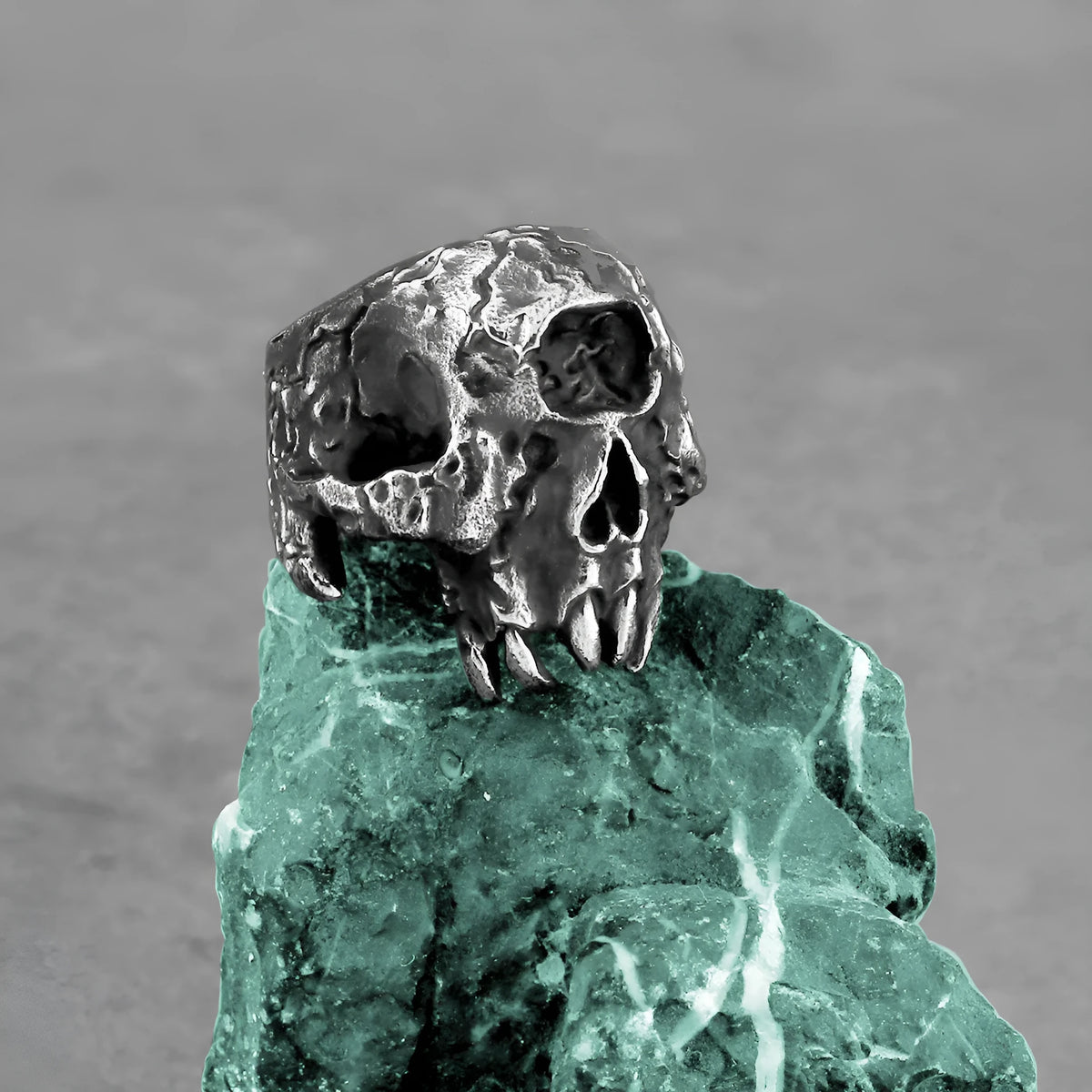 Alloy ring with a detailed one-eyed skull design on a finger, showing its metallic retro finish.