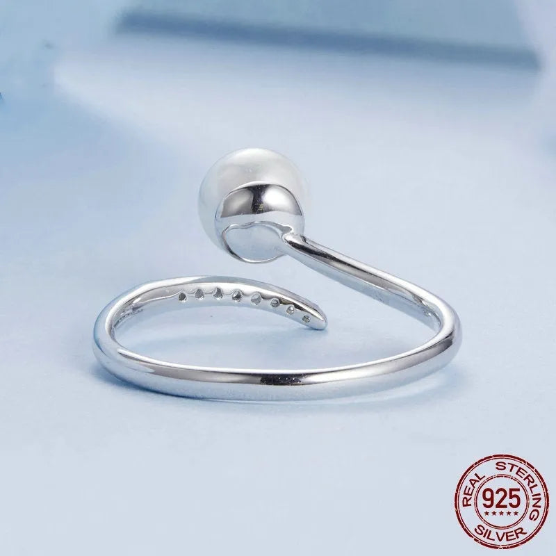 Adjustable open loop S925 sterling silver ring decorated with white shell pearls.