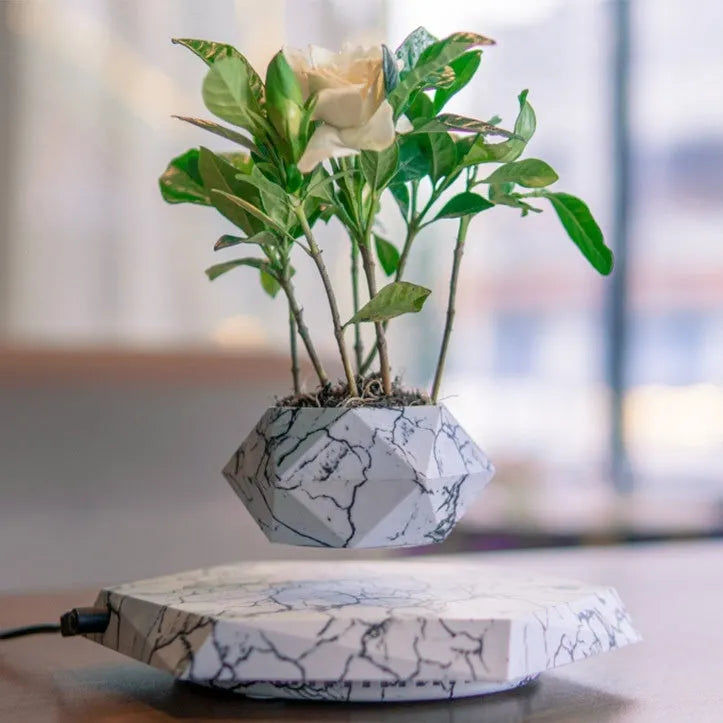 Small marble-colour plastic plant pot floating above a magnetic base unit.