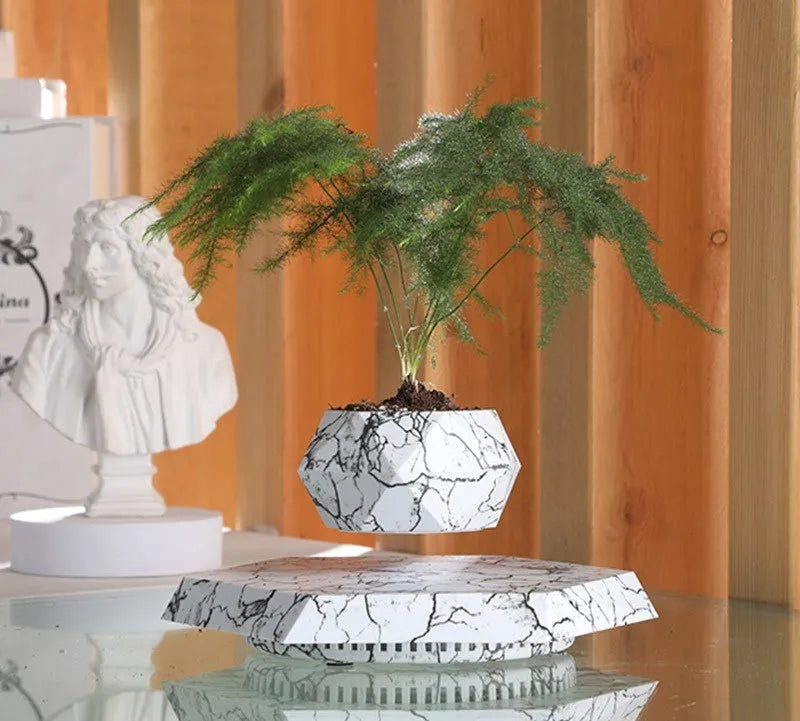 Small marble-colour plastic plant pot floating above a magnetic base unit.
