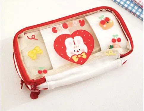 Transparent heart-shaped TPU pencil case in a pink multicolour Korean-style design with cake and rabbit motifs.