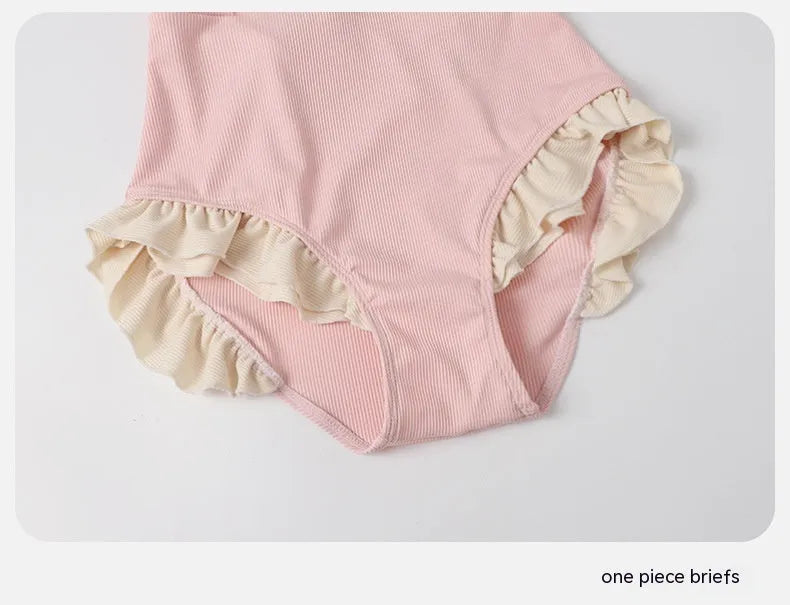 Pink women's conservative one-piece nylon swimsuit on a hanger.