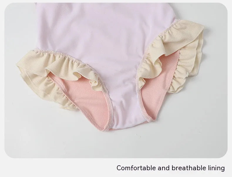 Pink women's conservative one-piece nylon swimsuit on a hanger.