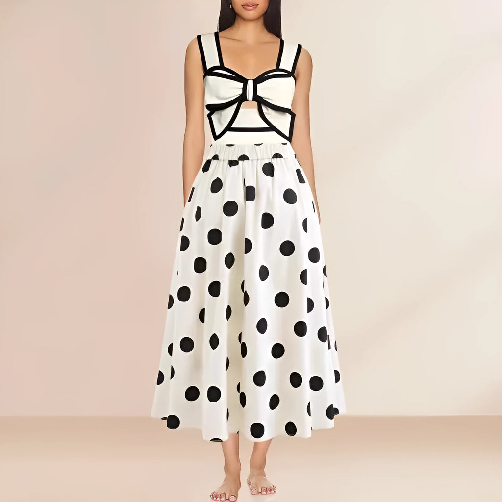 Women's black one-piece swimsuit with white round skirt and bow, worn as a beach dress.