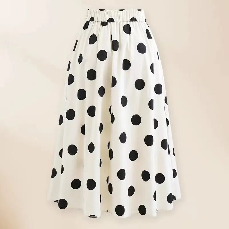 Women's black one-piece swimsuit with white round skirt and bow, worn as a beach dress.