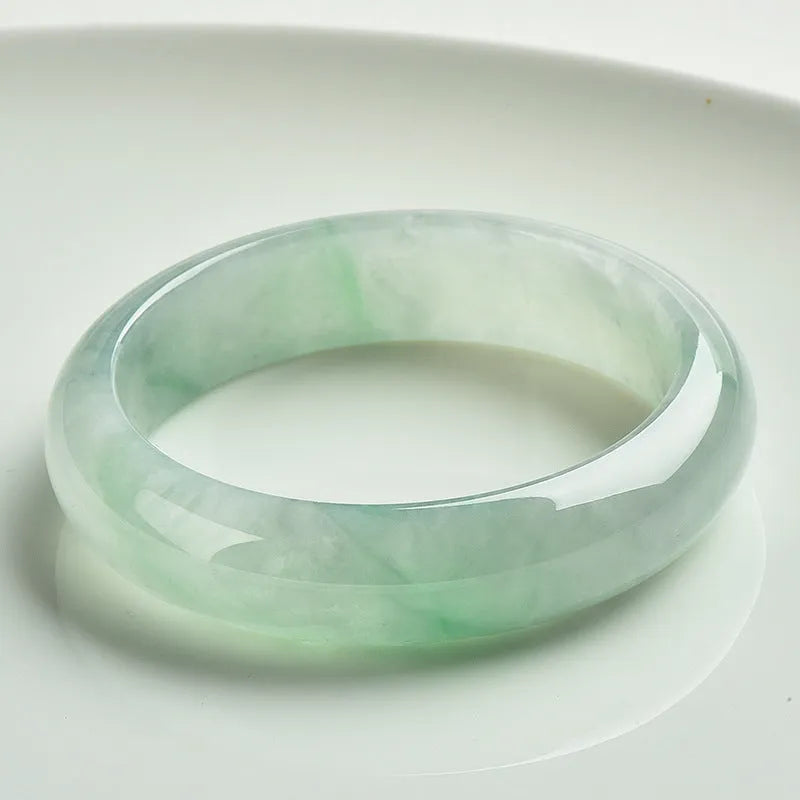 Light green jade bracelet showing natural stone colour and solid band construction