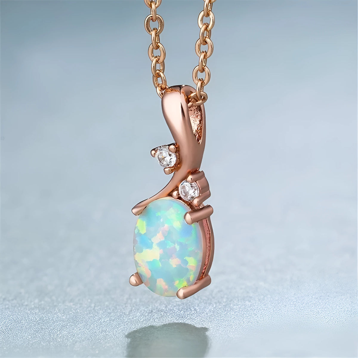 Water drop shaped opal pendant necklace on an O-chain in rose gold or white finish.