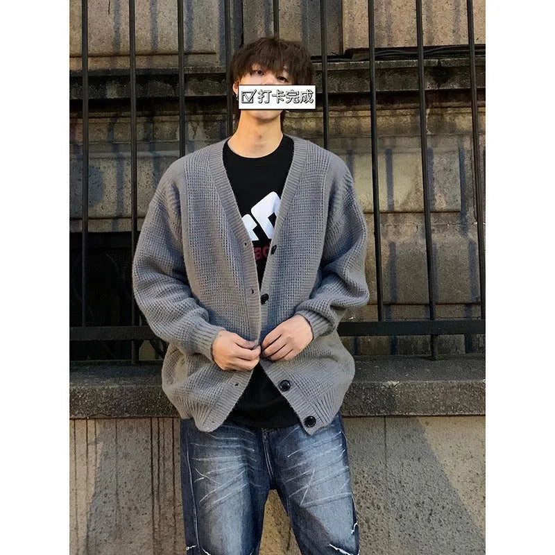 Men's loose fit V-neck cardigan sweater in a solid colour, shown on a casual model.
